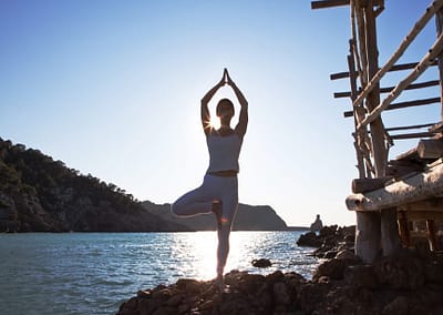 Opale-in-Vrkasana-Tree-pose-Yoga-at-Beniras-beach-in-Ibiza